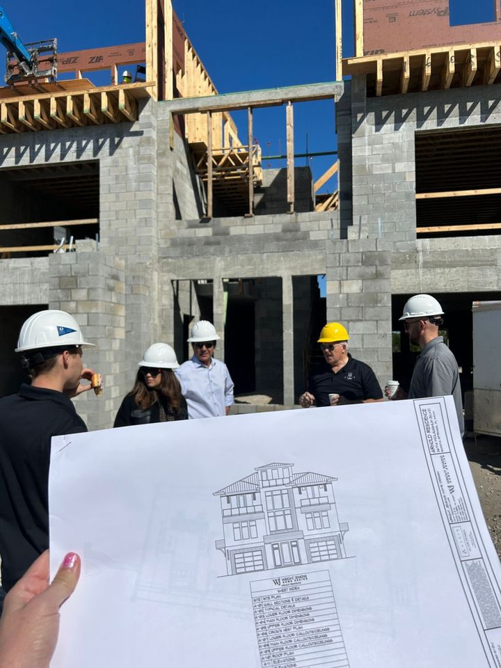 Equipo de BRAVA GLOBAL en supervisión de obra revisando planos arquitectónicos en sitio